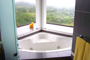 The jacuzzi in the 3-story house has around it large windows with a volcano view.